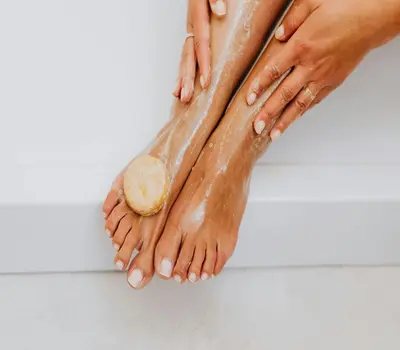 Close-up of woman washing feet with organic soap,