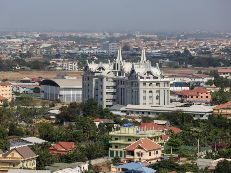 Aerial view of a modern cityscape with a unique white building as the focal point