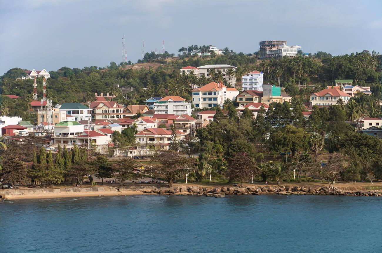 A coastal town with colorful houses and lush greenery near the water 