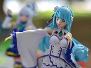 Close-up of a detailed anime figurine with blue hair and a white dress on display at a convention