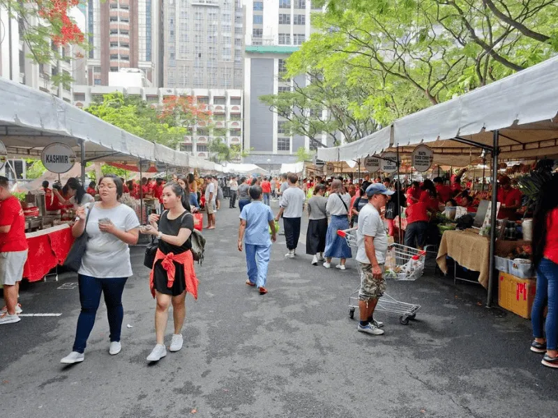 Shoppers exploring fresh produce and goods in an outdoor market