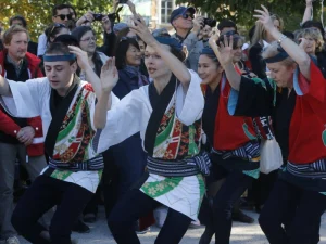 Group of dancers in colorful traditional attire performing during a Japanese festival.