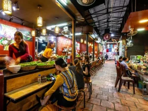 Cozy and vibrant dining area in a Cambodian market, with visitors enjoying traditional street food