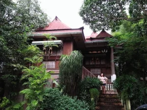 A traditional home surrounded by lush greenery and nature