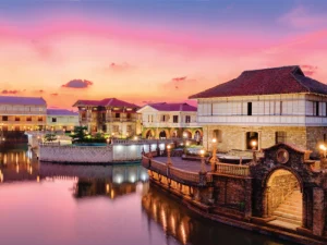 Colonial-style buildings reflecting on calm waters at Las Casas