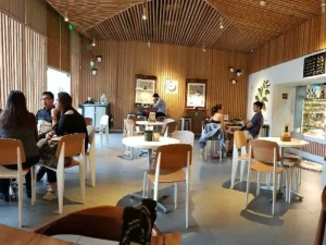 Cozy café interior with wooden accents and customers enjoying coffee.