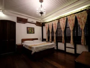 A cozy wooden bedroom with vintage furnishings and curtains