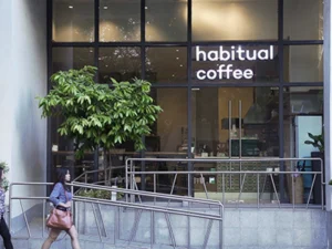 Habitual Coffee shop exterior with a pedestrian walking past it