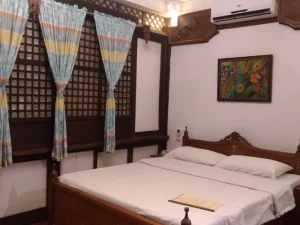 A well-lit room with a wooden bed and decor