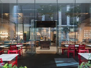Glass-walled outdoor seating area at Wildflour Café and Bakery