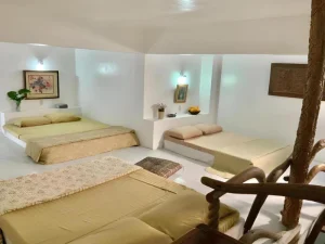 Spacious white room with multiple beds at Hacienda Isabella resort