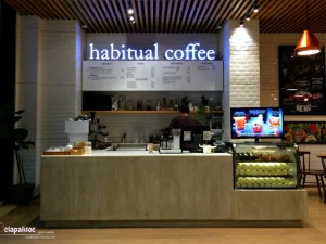 Counter of Habitual Coffee with menu board and dessert display case