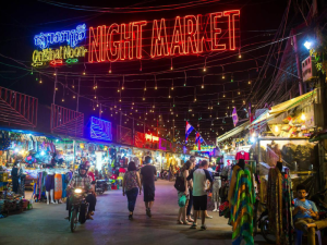 The vibrant Angkor Night Market at night, filled with stalls, colorful lights, and visitors enjoying shopping and local cuisine