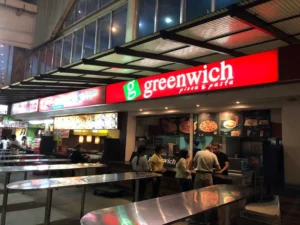 Greenwich Pizza Stop - Travelpreneur Greenwich Pizza fast-food restaurant at night with customers ordering food