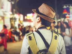 Back view of a tourist enjoying a vibrant night market stroll