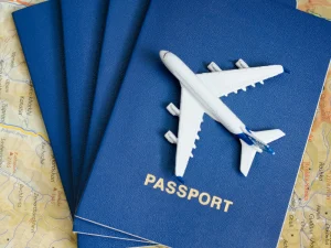Blue passports stacked with a miniature airplane on a world map