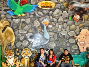 Zoobic Safari Mural - Travelpreneur A colorful mural at Zoobic Safari showcasing various animals, with visitors sitting in front, enjoying the artistic display