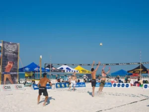 Players engaged in a volleyball game on a sandy beach