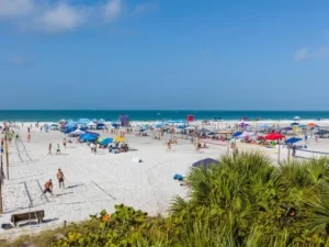 A beachside festival with tents, people, and ocean views