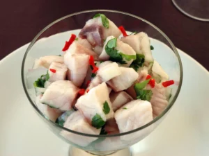A glass of fresh ceviche with cilantro and red chili