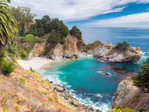 A turquoise cove surrounded by cliffs and lush greenery