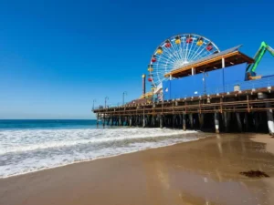 A Ferris wheel on a wooden pier overlooking the ocean