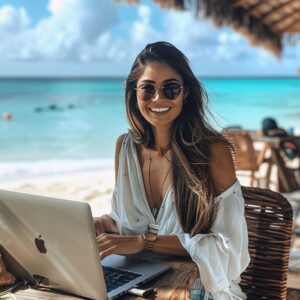 1 beachside-remote-work-stockcake - Travelpreneur A woman smilling at the camera while remotely working at a beach