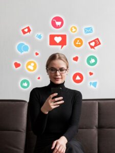 a woman happily engaging and using her phone as different icons related to social media surrounds her