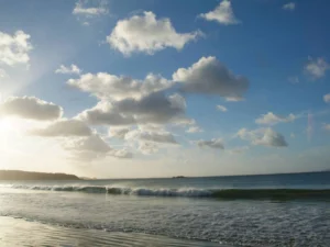 Peaceful beach sunset with calm ocean and cloudy sky