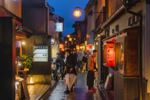 pontocho 2 - Travelpreneur a busy alley of pontocho filled with people and lighted stores.