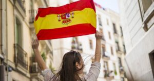 spain - Travelpreneur a woman holding the flag of spain