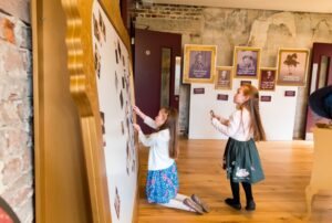 Highcliffe Castle Drawing Room converted to a interactive museum were visitors are interacting with museum exhibit