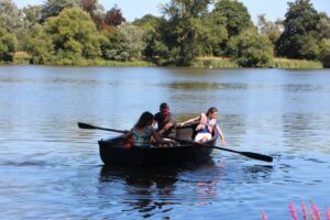 a family rowing on a boat at the hever castle lake