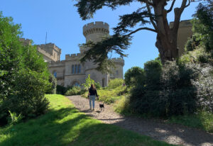 11 Dog Walk - Travelpreneur Eastnor Castle Dog Walk Path towards the castle with a visitor and her dog walking to the castle