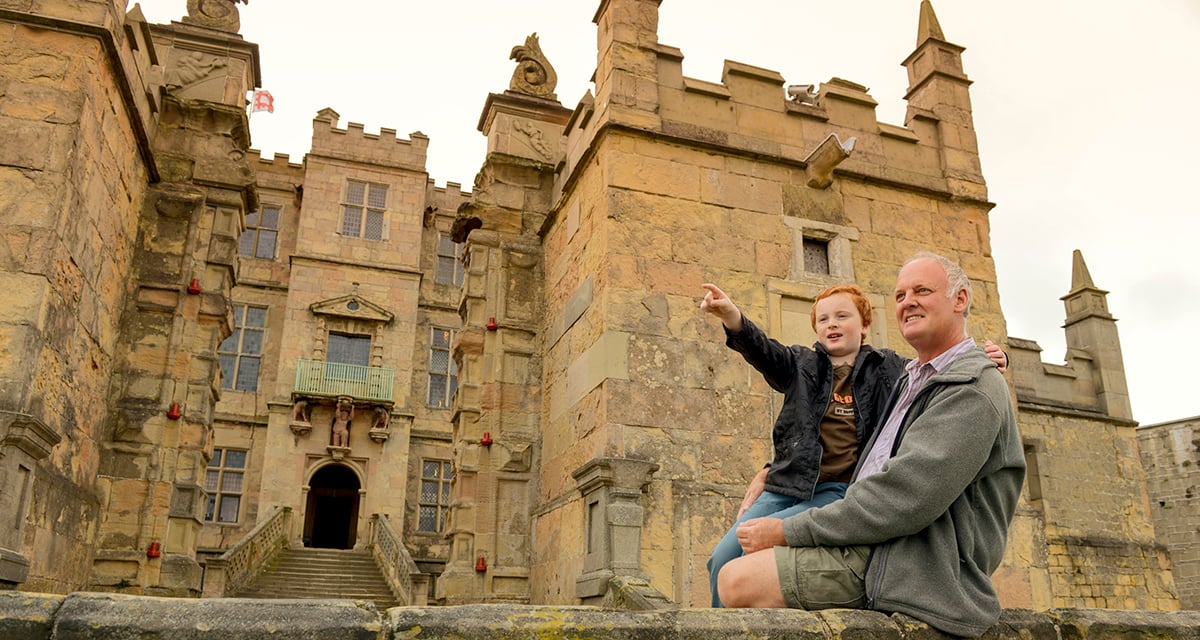 A father and child happily taking a walk with the Bolsover Castle on the background