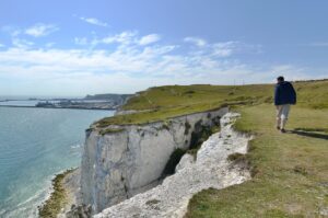 2l visitor-walking-along-the-clifftop-at-the-white-cliffs-of-dover-kent - Travelpreneur White Cliffs of Dover breathtaking cliff side walk path