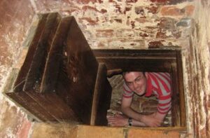 Oxburgh Estate Priest Hole and a man inside the hole with open door