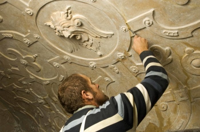 Apethorpe Palace staff doing preservation work on a ceiling carving