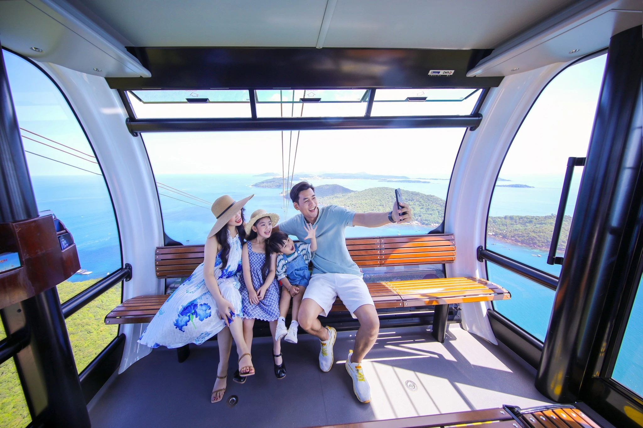 a happy family of 4 riding Hon Thom Cable Cart