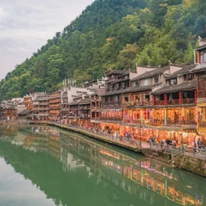 Riverside historic town with lantern-lit shops and restaurants, showing how heritage supports evening tourism economies
