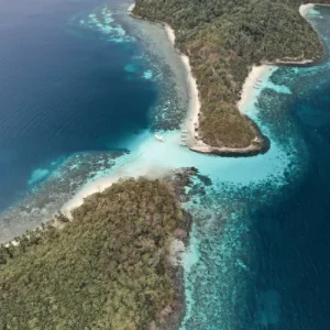 Drone shot of sandbar between islands with boats anchored, promoting sustainable marine tourism experiences locally