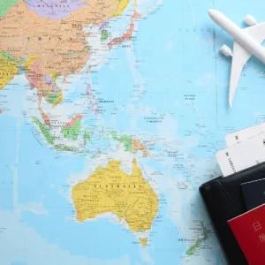 Travel Planning Map - Travelpreneur Flatlay of Asia-Pacific map, passports, and toy airplane, symbolizing outbound tourism planning and budgeting decisions