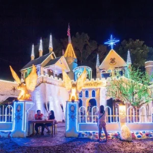 Colorful lighted church facade at night, visitors gather, Holidays in the Philippines Christmas display glowing