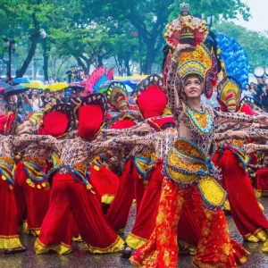Street dancers in ornate costumes perform in parade, Holidays in the Philippines crowd watches nearby