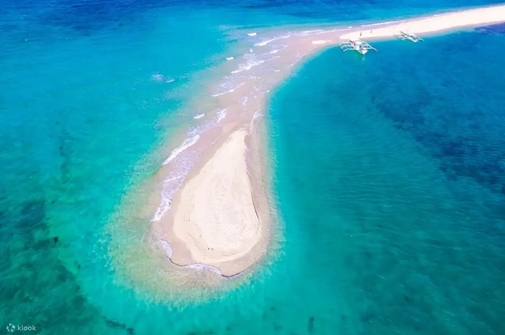 Bantigue Island Sandbar, Iloilo - Travelpreneur Drone perspective of the winding white sandbar of Bantigue Island in Gigantes, surrounded by clear shades of turquoise and deep blue ocean water.